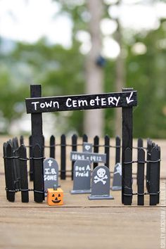 a miniature town cemetery with pumpkins and tombstones