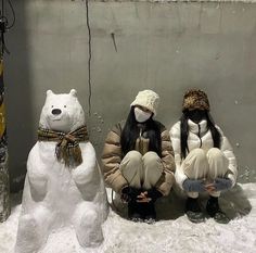 three snowmen sitting next to each other in front of a wall with two bears