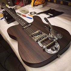 an electric guitar sitting on top of a table next to other musical instruments and tools