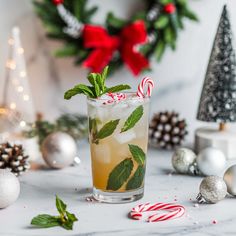 a holiday drink with mint and candy canes on the table next to christmas decorations