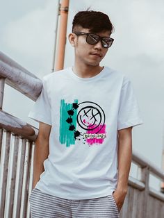 a young man standing on a bridge wearing sunglasses and a t - shirt with the word peace painted on it