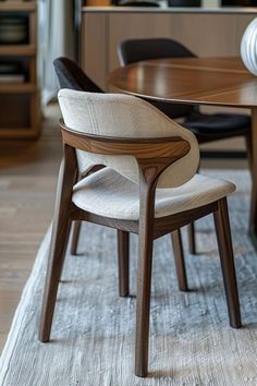 a dining room table with chairs and a rug on the floor