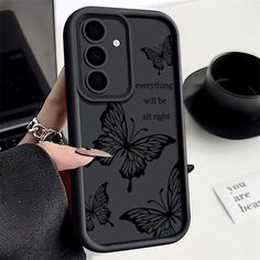 a woman is holding her phone case with butterflies on it and the words everything will be all right