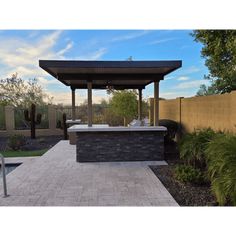 a gazebo in the middle of a backyard with a hot tub and patio furniture