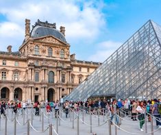 many people are walking around in front of a building with a glass pyramid on it