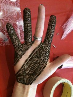 a henna on someone's hand next to a roll of tape