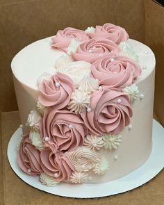 a white and pink cake with flowers on it