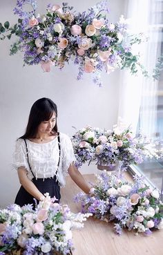 a woman standing in front of a table filled with flowers