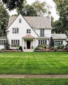 a white house surrounded by lush green grass