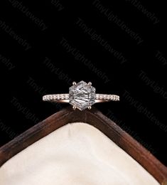 an engagement ring on top of a white cloth