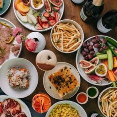 a table full of different types of food on plates and bowls next to each other