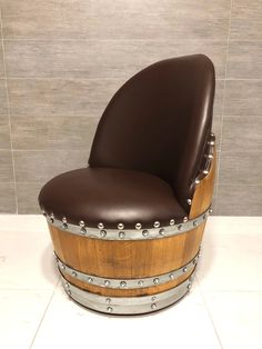 a wooden barrel chair sitting on top of a white tile floor next to a wall