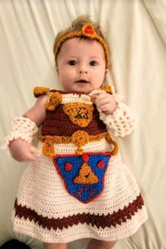 a baby is wearing a crocheted bear outfit and holding a teddy bear in it's arms