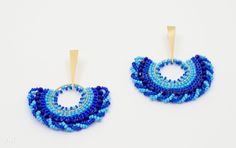 two pairs of blue beaded earrings with gold hoops on top of each other