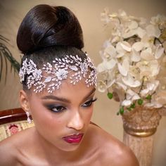 a woman wearing a bridal headpiece with flowers in the back and on top