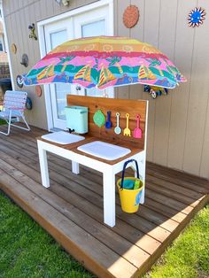 an umbrella is on top of a small table with utensils and other items