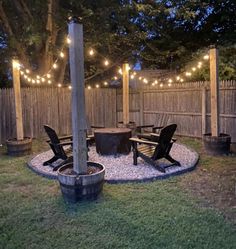 an outdoor patio with lights strung over it and chairs around the fire pit in the back yard