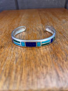 Beautiful Sterling Silver Turquoise and Lapis lazuli Inlaid Cuff Bracelet measuring approx 6 3/4" interior circumference including the gap of 1 3/8" and 3/8" wide, marked CCO925 Southwestern Blue Cuff Bracelet As Gift, Adjustable Turquoise Bracelet With Inlay, Adjustable Turquoise Inlay Bracelets, Adjustable Southwestern Blue Cuff Bracelet, Southwestern Style Blue Bangle Bracelets, Bohemian Blue Bracelets With Inlay, Southwestern Style Blue Bangle Bracelet, Blue Inlay Bracelet Jewelry, Blue Inlay Bracelet