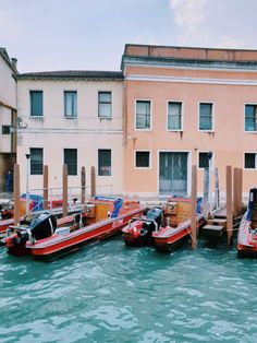 several boats are parked in the water next to buildings