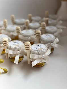 several honey jars with white bows and labels on them