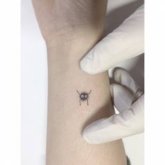 a small spider tattoo on the left side of the arm by someone's hand