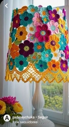 a crocheted lamp shade with flowers on it