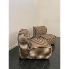 two chairs sitting on top of a black tile floor next to a white and brown wall