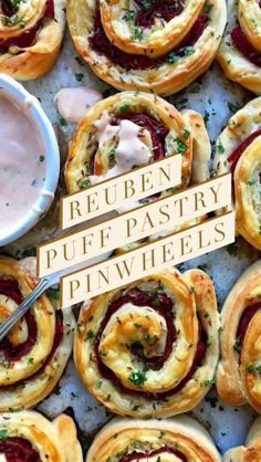 many pastries are arranged on a tray with a sign that says reuben puff pastry pinwheels