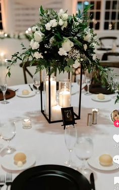 a table with candles, flowers and plates on it is set up for a wedding reception