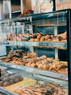 a display case filled with lots of different types of doughnuts and pastries