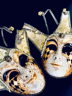 two masquerade masks sitting on top of each other