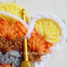 the crocheted butterfly is holding a pair of scissors