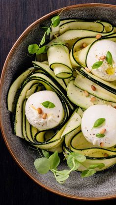 zucchini with poached eggs and herbs in a bowl on a table