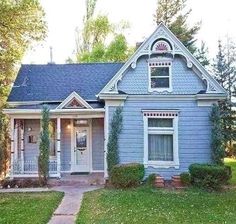 a blue house with white trim on the front door and windows is shown in this photo