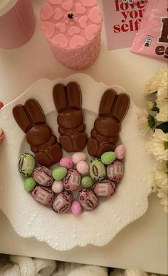 a white plate topped with chocolate bunny hands and candy candies on top of it