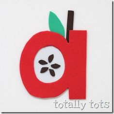 the letter q is made out of paper and has an apple on it