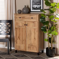 a wooden cabinet sitting next to a potted plant