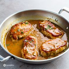 three pieces of meat covered in sauce in a pan