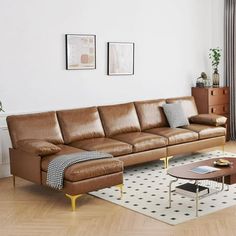 a living room with a couch, coffee table and two pictures on the wall above it