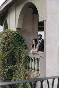 a man and woman are standing on a balcony