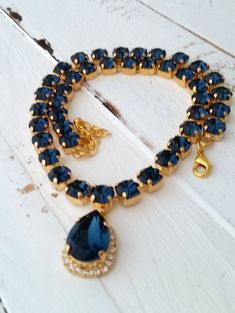 "Navy blue crystal Swarovski necklace, Navy blue, Statement necklace, Bridal necklace, Bridesmaids gift, Tennis necklace,Wedding jewelry Exquisite piece of jewelry!! MADE TO ORDER WITH CUSTOM COLOR STONES AND PALTING. Please contact me. This is a breathtaking sparkly necklace will attract tons of attention. It is made with deep blue teardrop and 8 mm stones. The length of the necklace is 41 cm (16.14 inch) and has an extension chain of 9 cm (3.5 inch) for adjustment. Made with gold plated and Sw Blue Crystal Rhinestone Necklace For Wedding, Elegant Blue Rhinestone Necklace For Wedding, Sapphire Crystal Bridal Necklace Gift, Blue Crystal Necklaces For Wedding, Blue Crystal Bridal Necklace Gift, Blue Crystal Necklace For Wedding, Blue Crystal Bridal Necklace For Gift, Sapphire Jeweled Necklace For Wedding, Sapphire Choker