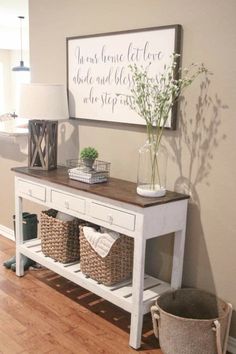 a white table with baskets on it next to a lamp