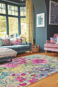 a living room filled with furniture and lots of window sill space next to a colorful rug