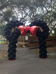 an arch made out of black balloons and red hearts