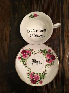 two cups and saucers with roses on them, one has the words you're brew