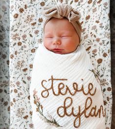 a baby wrapped in a blanket with the words steve dylan written on it