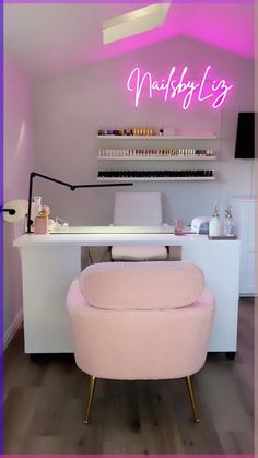 a pink chair sitting in front of a desk with a neon sign on top of it