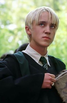 a young man with blonde hair wearing a green tie