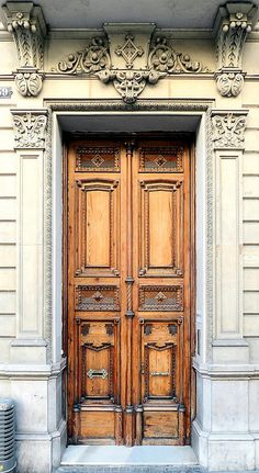 two large wooden doors are on the side of a building