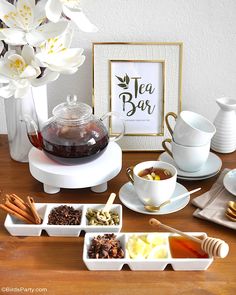 a table topped with cups and bowls filled with tea